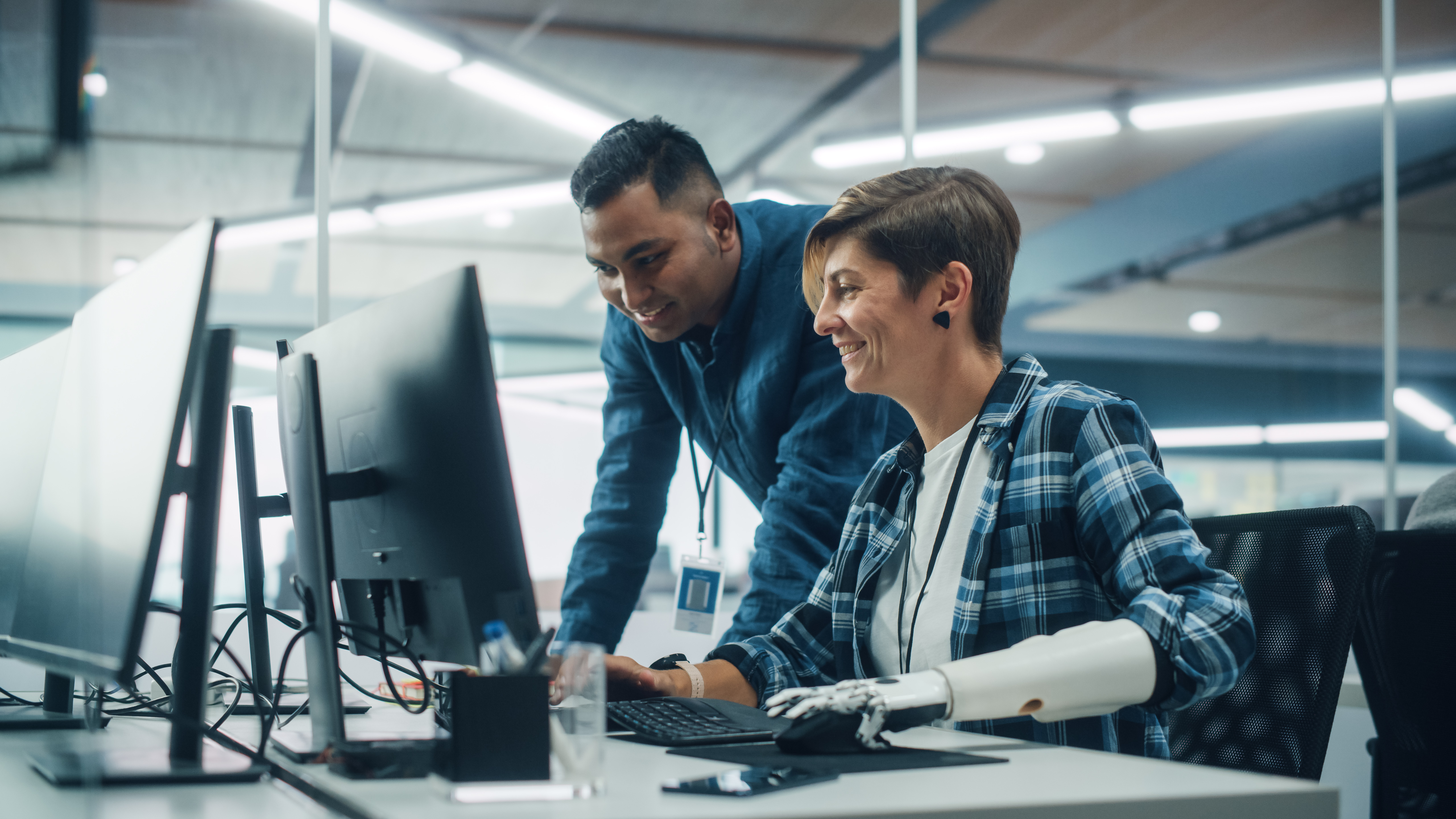 Two office workers smiling on a computer