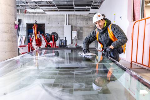 Employers sign-up your apprentice window glazier young man preparing a window for installation hard hat cleaning window blue-collar worker building clothing composite material footwear indoor person workwear