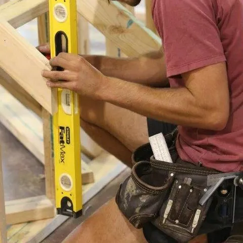 Disability DIAP MEGT young man carpenter carpentry protective ear coverings spirit level timber frame blue-collar worker carpenter clothing handyman man outdoor person tool