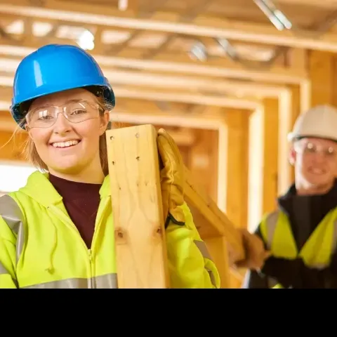 Two people on work site wearing hi vis