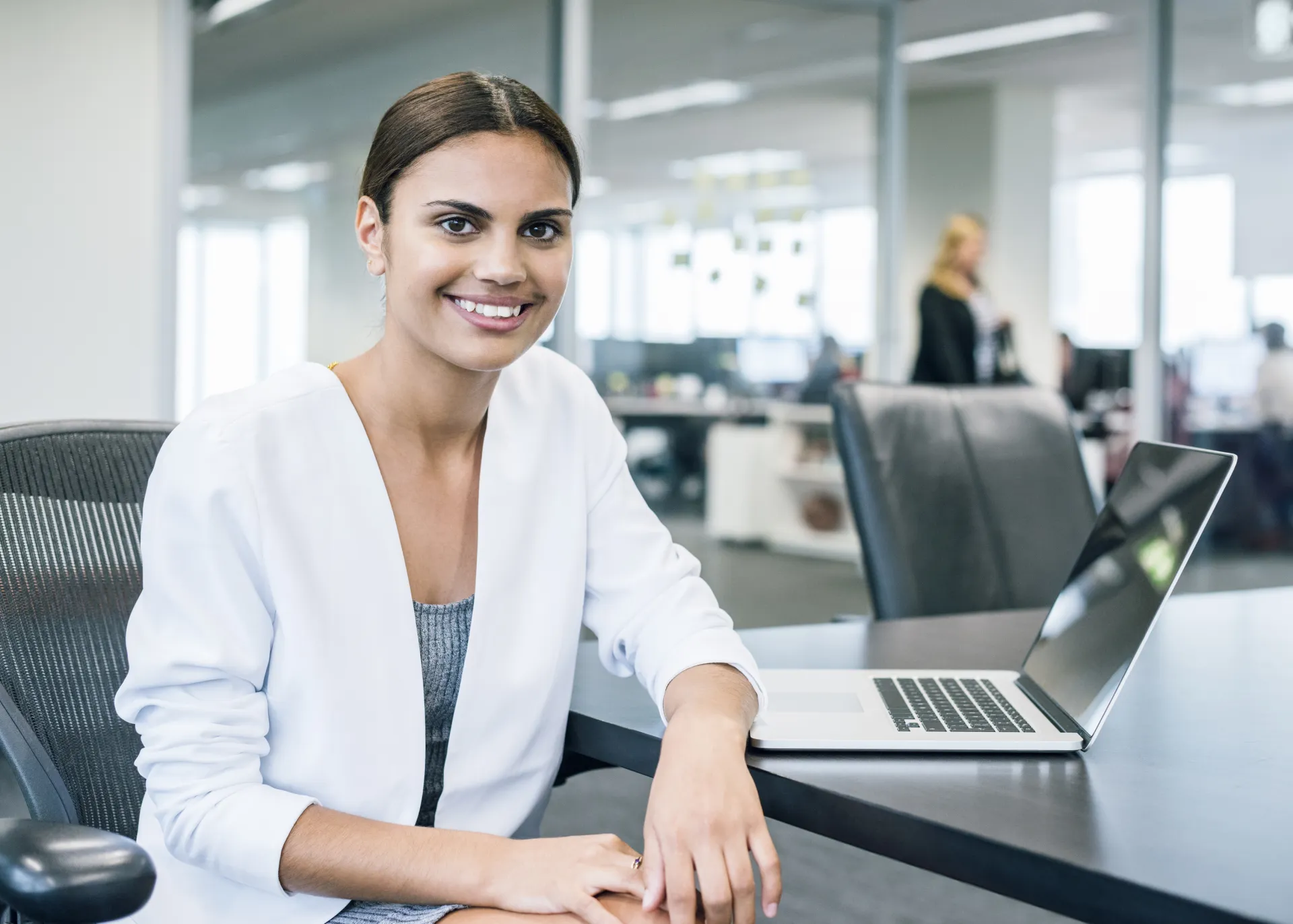 smiling First Nations woman First Nations Banking Traineeship young First Nations woman sitting at a desk in front of her laptop computer office clothing computer desk human face indoor job laptop office building person personal computer smile wall woman 