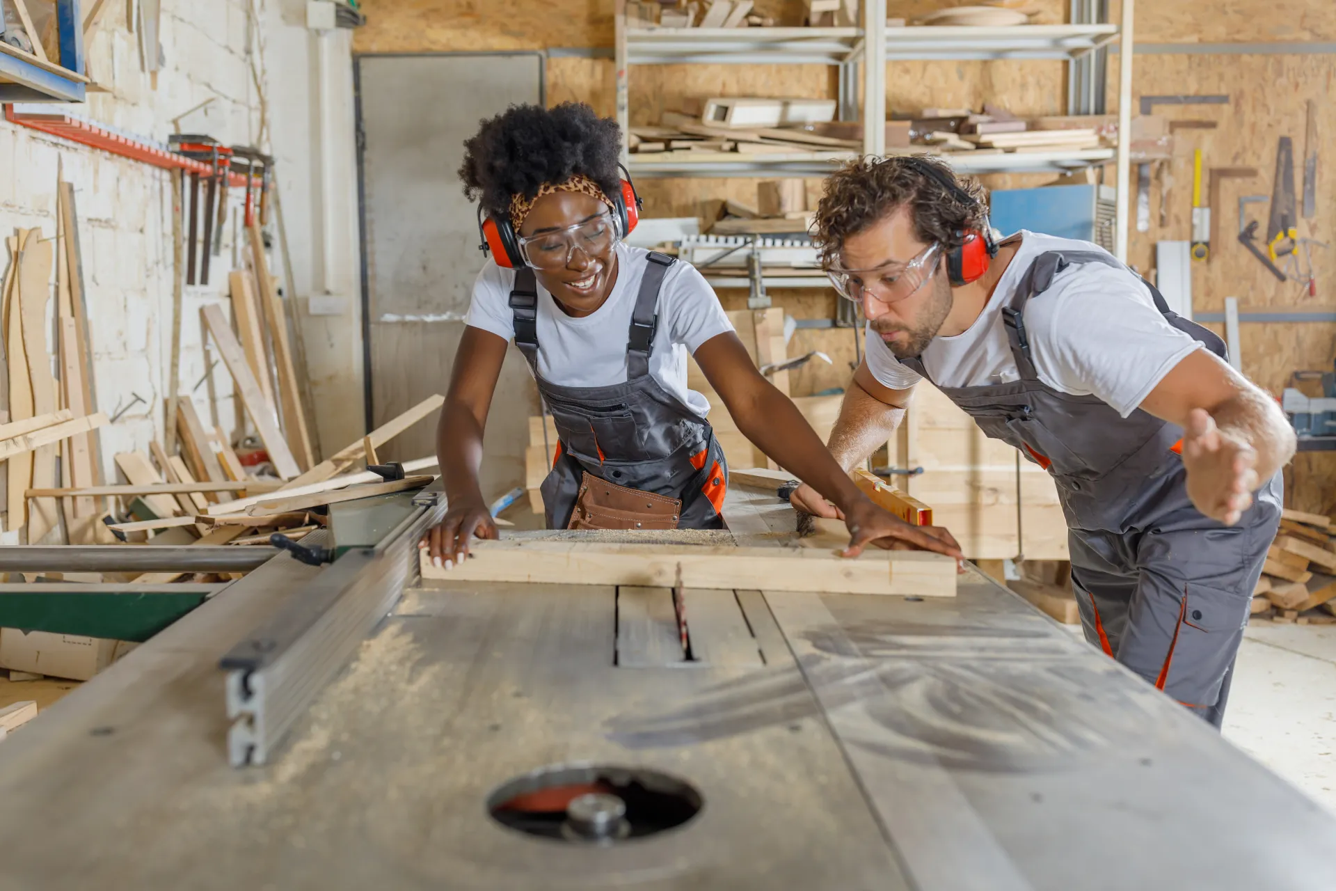 cabinet maker woodwork sawing electric saw mentor mentoring Labour Hire factory indoors wood cutting young woman cutting timber with electric saw guidance instructions artisan blue-collar worker carpenter clothing person tool carpentry labour hire