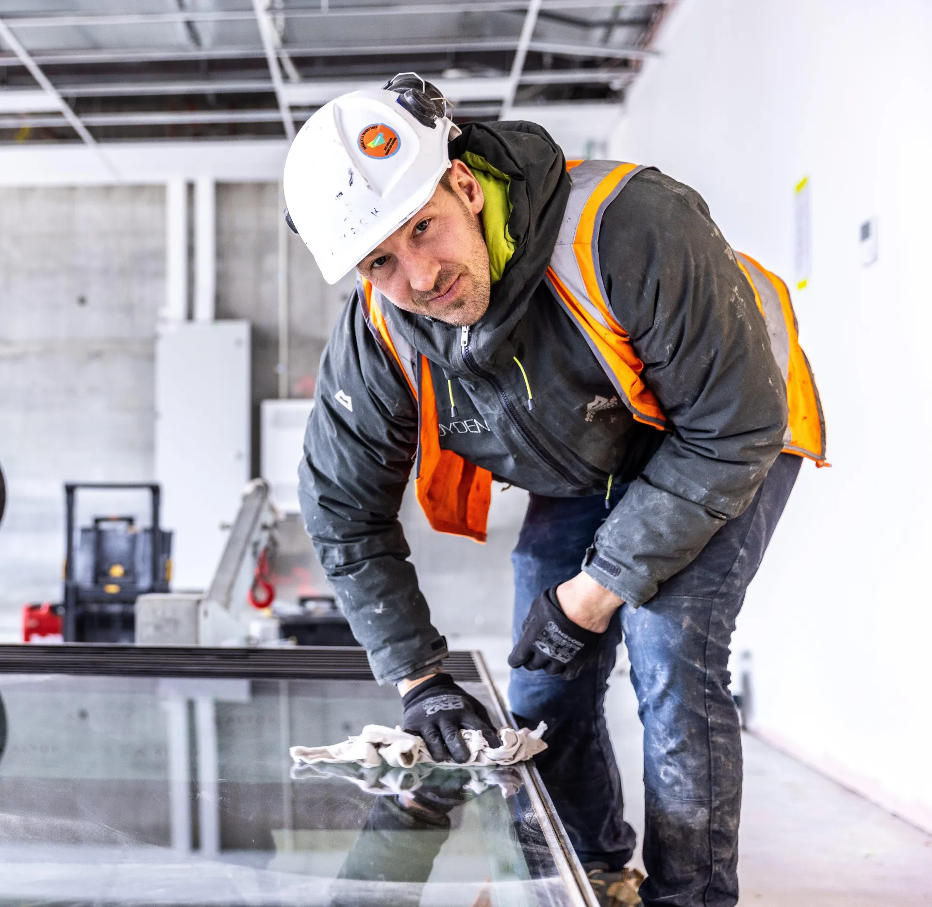 male in PPE wiping down glass